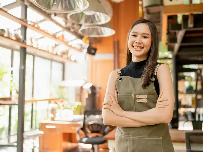Smiling small business owner in a modern shop, serving customers and promoting services on Local Biz Directory Now